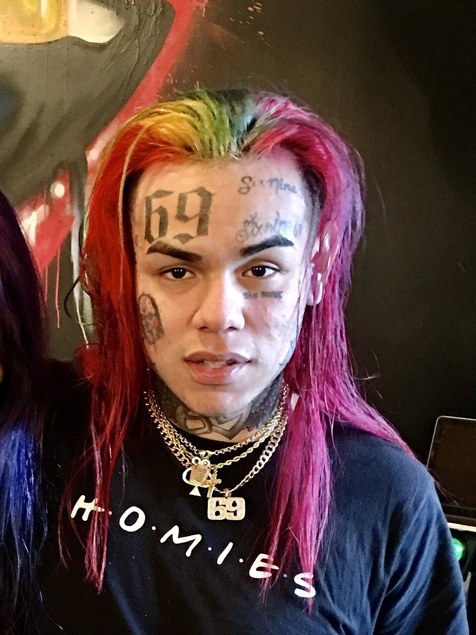 Tekashi 6ix9ine portrait with rainbow hair and face tattoos